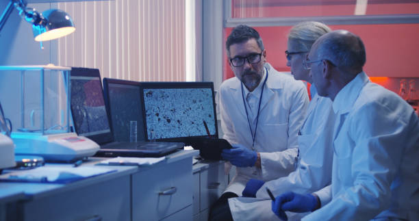 Medium shot of three scientists watching monitor and analyzing